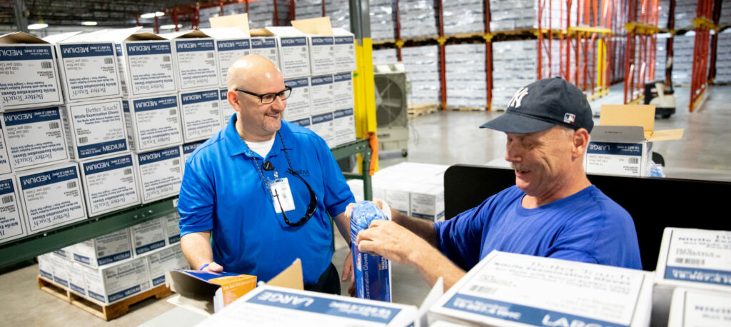 A visually impaired glove packager talking to general manager, Ron Baron, on the glove line.