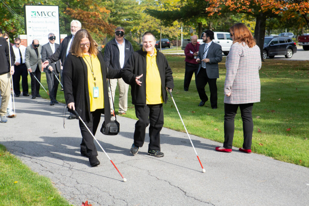 Several visually impaired people walking around using white canes.