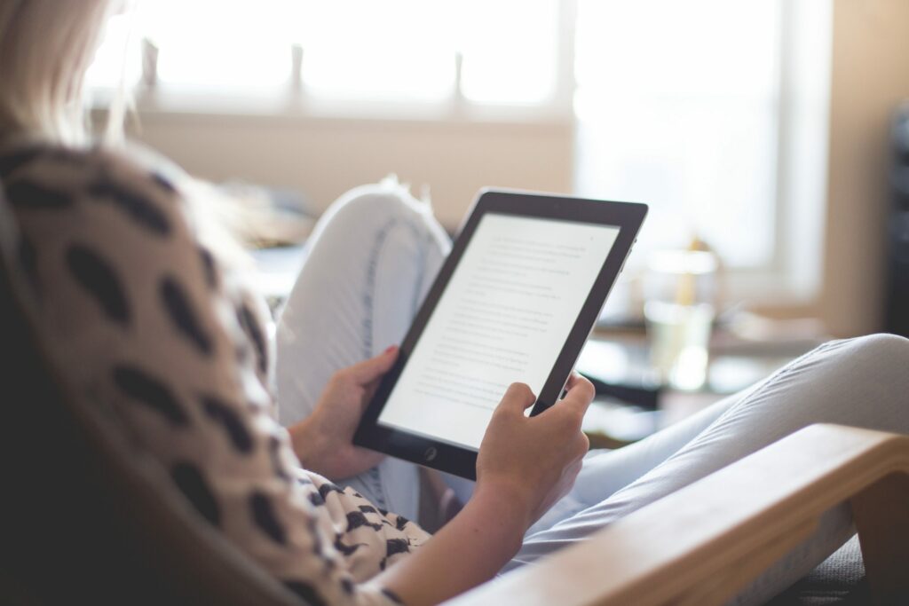 A woman reading a tablet.