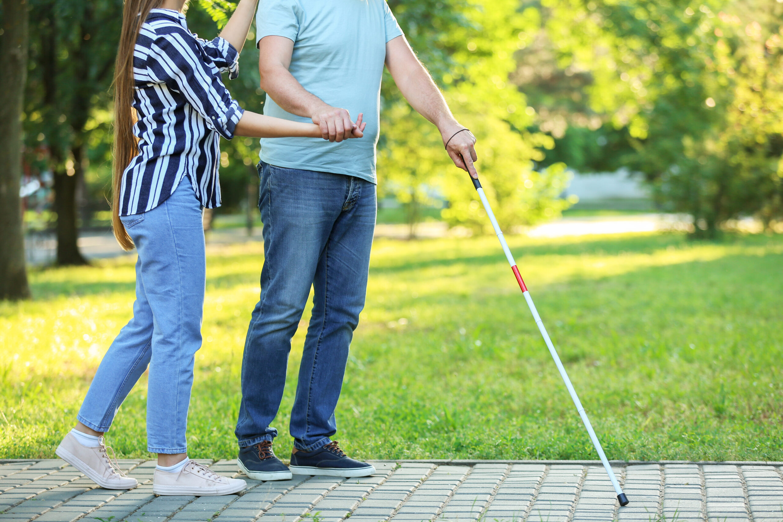 Blind mature man with daughter walking in park